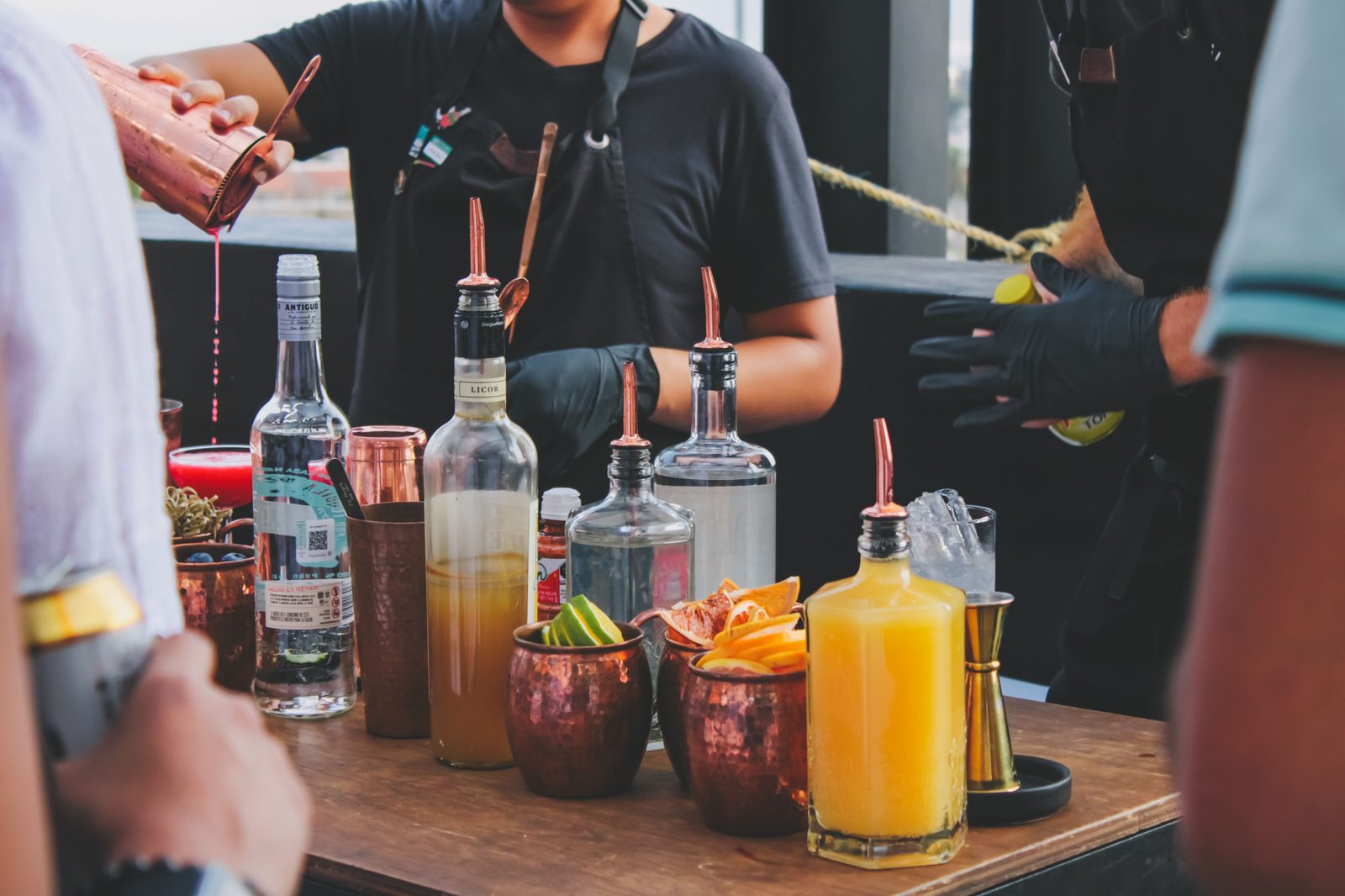 Bartender pouring cocktails at a rooftop event (stock photo)