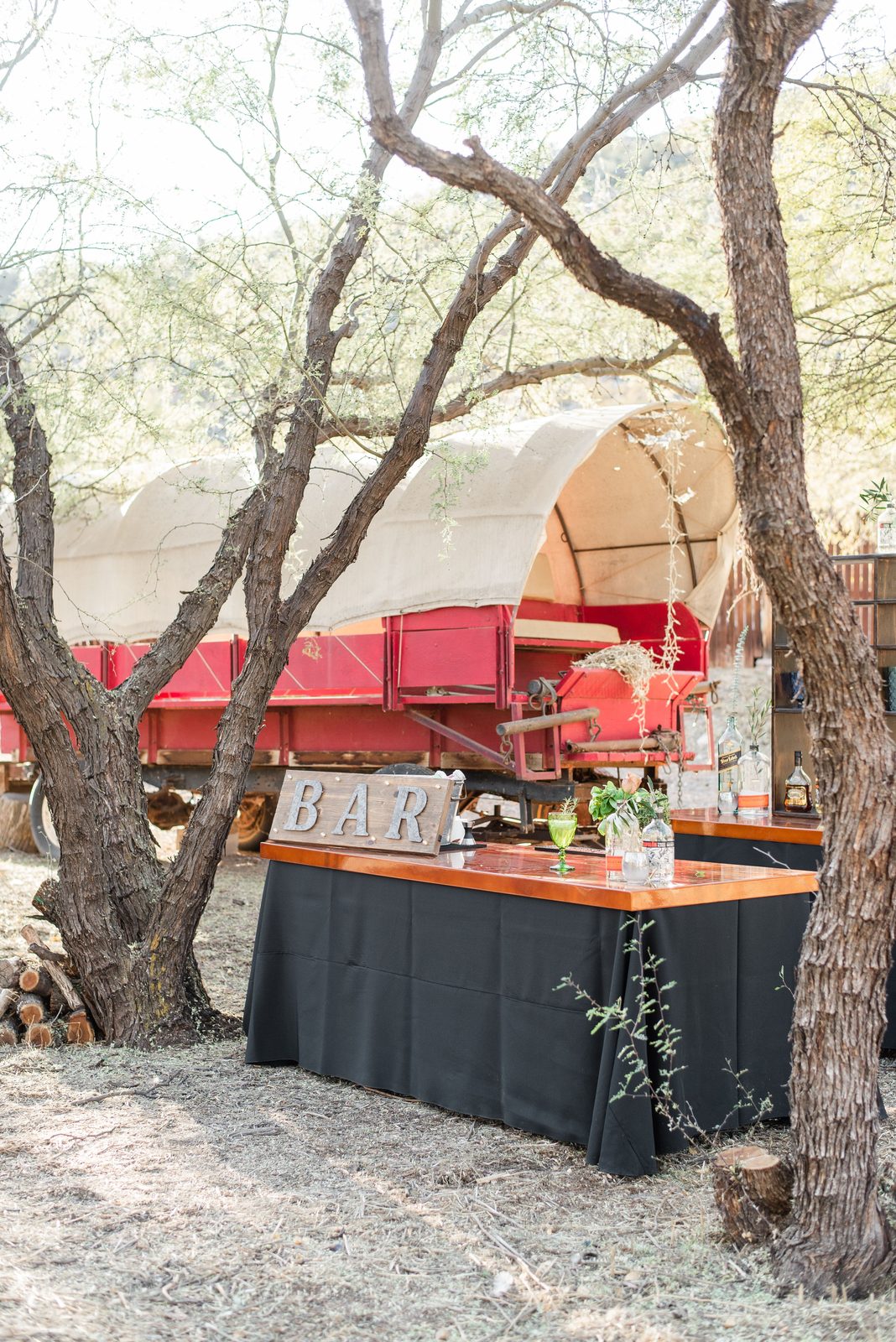 Rustic outdoor bar setup with wagon backdrop (stock photo)