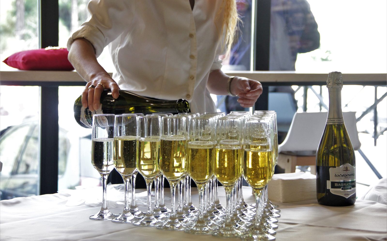 Lineup of champagne flutes ready to pour (stock photo)